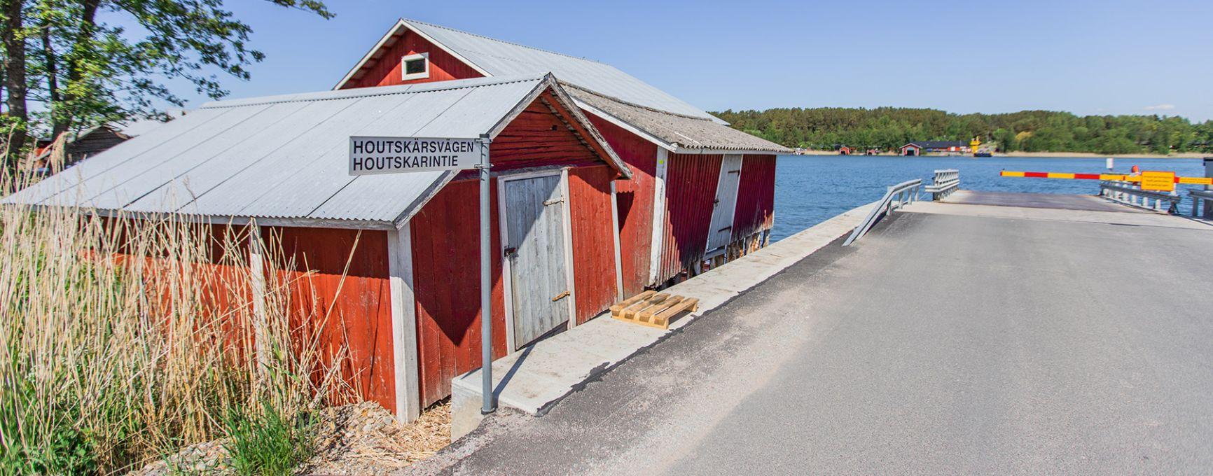 A ferry stop on Houtskär, next to a traditional wooden building.